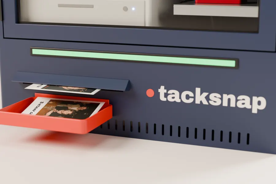 A print sliding out of the Tacksnap box into its red tray