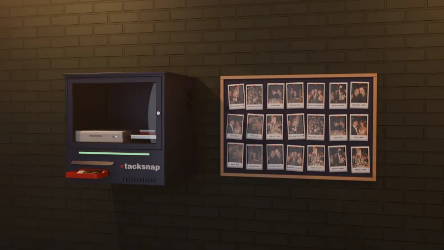 A Tacksnap box on a brick wall next to a pin board full of prints